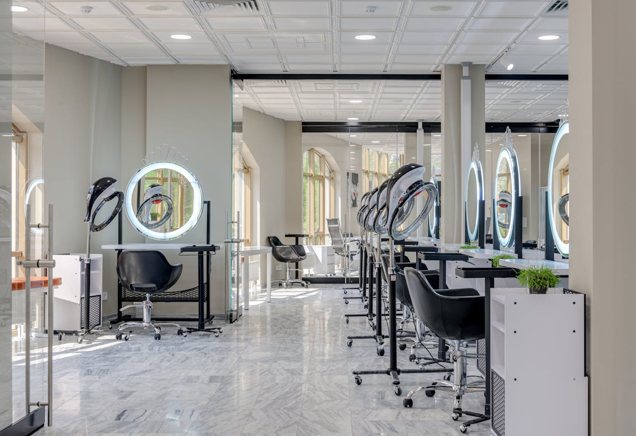 Bright and spacious hair salon interior featuring modern design elements and vanity mirrors.